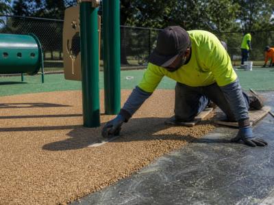 Rubber surfacing being spread at a dog park