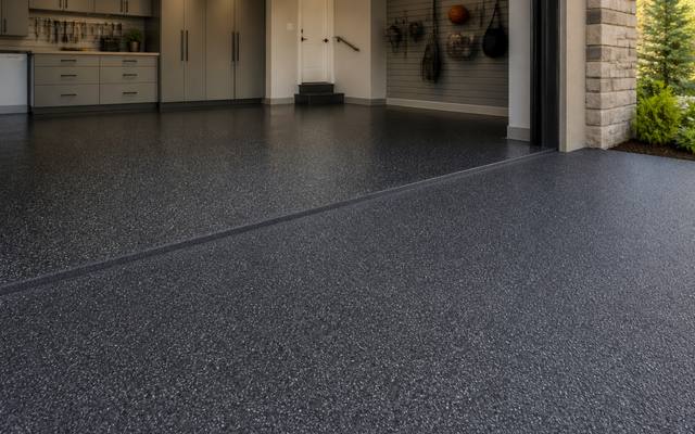 Dark speckled rubber surfacing covering a garage floor from wall to wall.